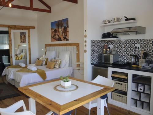 1 dormitorio con 1 cama, mesa y sillas en Wildhorses B&B and Self Catering en Lüderitz