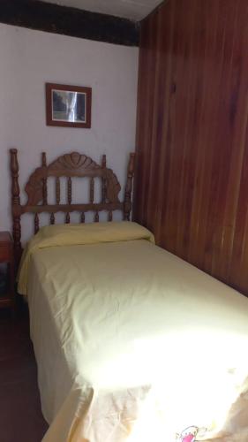 a bedroom with a bed with a wooden head board at Casa Nina in San Cristóbal de Las Casas