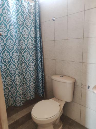 a bathroom with a toilet and a shower curtain at Guest House Villa Machalilla in Machalilla