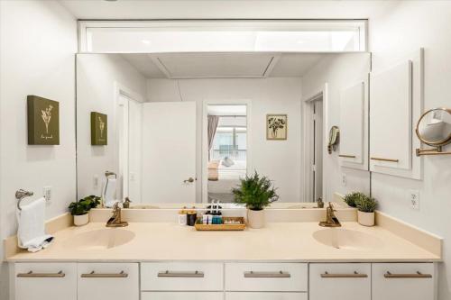 un bagno con due lavandini e un grande specchio di Luxe 3 Story Townhome with Downtown View Near NRG Stadium Centrally Located Walkable To Popular Restaurants sleeps 8 a Houston