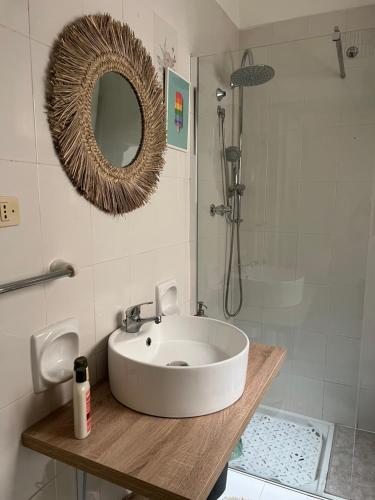La salle de bains est pourvue d'un lavabo, d'un miroir et d'une douche. dans l'établissement 10 MAGGIO APARTMENTS, à Augusta