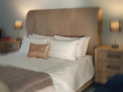 a bedroom with a bed with white pillows at Charis on Beaumont Theatre in Ramsgate