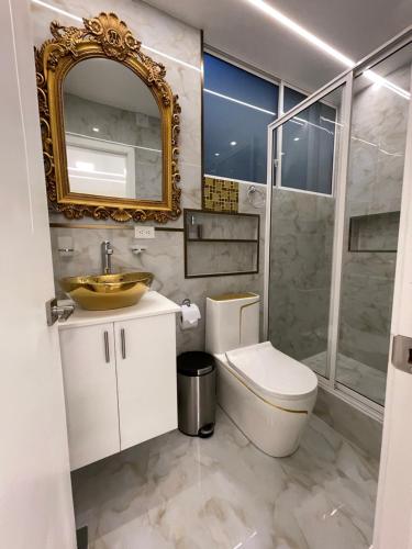 a bathroom with a toilet and a sink and a mirror at Hostal Balcon del Cielo in Baños