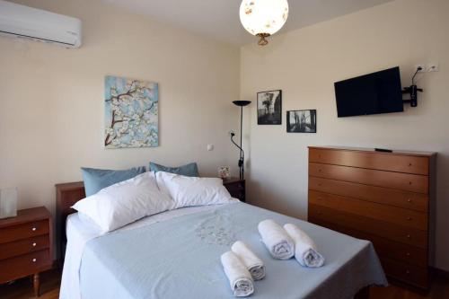 1 dormitorio con 1 cama con 2 toallas en Gaia cottage with garden en Epanomi