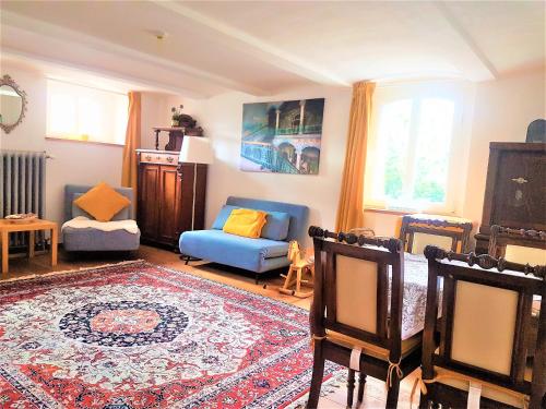 a living room with a blue couch and a rug at Deluxe Appartement bis 6 Personen Halbpension buchbar im Oberharz Unik Villa in Sankt Andreasberg