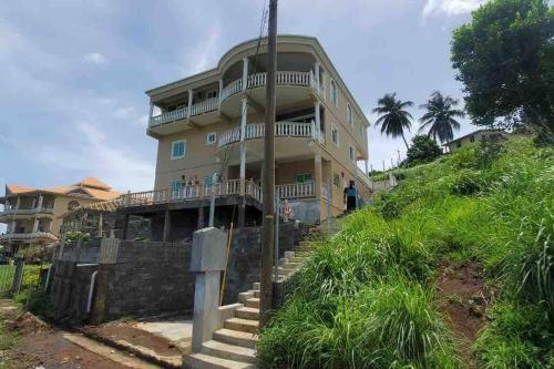 a house on a hill with a man standing in front of it at Ark Royal of the Caribbean in Arnos Vale