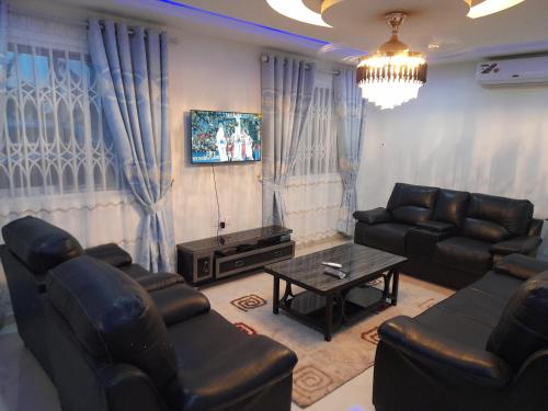 a living room with couches and a coffee table at Atom Height Apartments in Tema