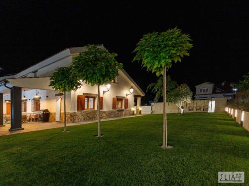 two trees in the yard of a house at night at Villa Eliá in Arcas
