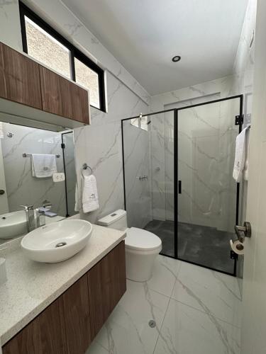 a bathroom with a sink and a toilet and a shower at HOTEL & BUNGALOWS VILLA PALMERAS LUNAHUANA in Lunahuaná
