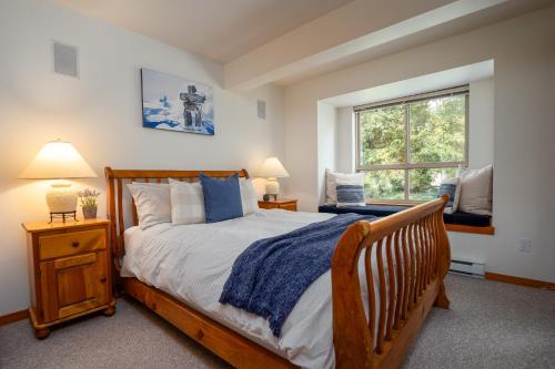 - une chambre avec un lit en bois et une fenêtre dans l'établissement Bright Multi-Level Home, à Whistler