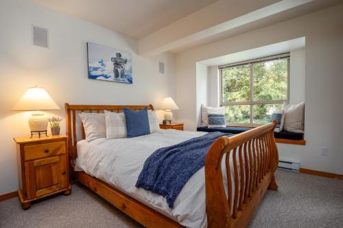 a bedroom with a wooden bed and a window at Bright Multi-Level Home in Whistler