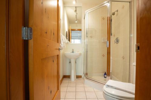 y baño con aseo, lavabo y ducha. en Bright Multi-Level Home, en Whistler