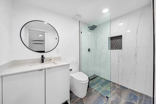 Baño blanco con aseo y espejo en Home In Fort Lauderdale 3 Bedrooms & private pool!, en Fort Lauderdale