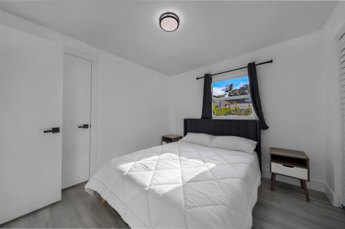 Habitación blanca con cama y ventana en Home In Fort Lauderdale 3 Bedrooms & private pool!, en Fort Lauderdale