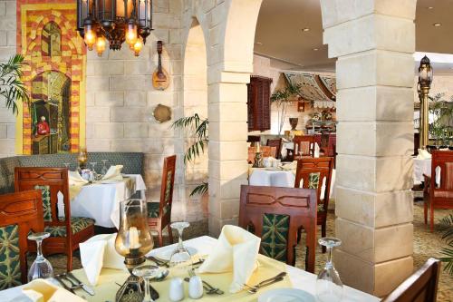 Un restaurante con mesas y sillas blancas y una columna. en Sunrise Holidays Resort -Adults Only, en Hurghada