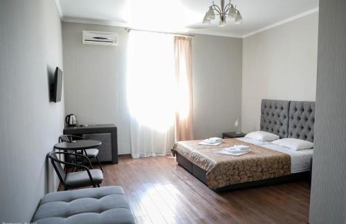 Habitación de hotel con cama y silla en Amore Hotel, en Gudauta