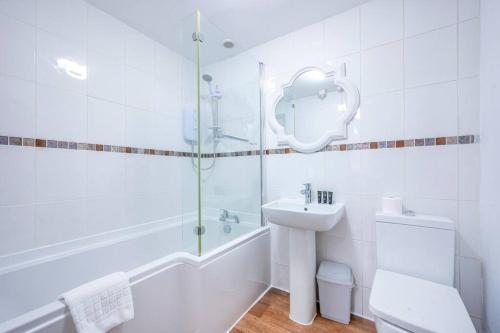 a white bathroom with a sink and a shower at *F2GH* for your most relaxed & Cosy stay + Free Parking + Free Fast WiFi * in Bramley