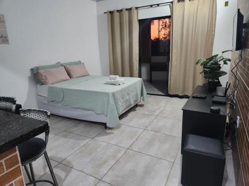 安格拉杜斯雷斯的住宿－Aconchego da Floresta，客厅配有床和桌子