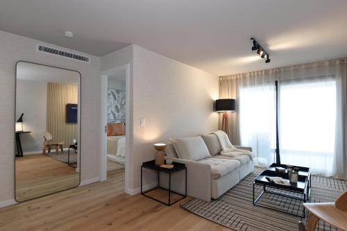 uma sala de estar com um sofá branco e um espelho em Vistas al Mar en Exclusivo Apartamento con Garage em Montevidéu