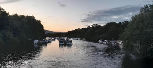 a group of boats in a river at sunset at Loch Lomond Apartment in Alexandria