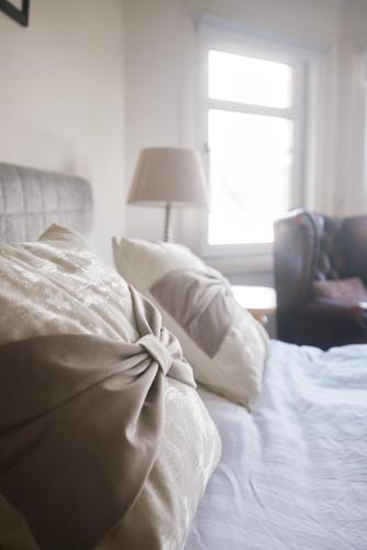 a white bed with a bow on top of it at Loch Lomond Apartment in Alexandria