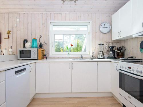 Sønderbyにある8 person holiday home in Juelsmindeの白いキャビネットと窓付きのキッチン