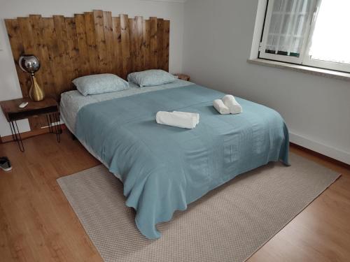 a bedroom with a bed with two towels on it at Segredos da Montanha - Seia in Seia