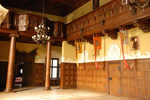 a large room with wooden doors and a chandelier at Zamek Czocha in Leśna