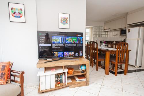 eine Küche und ein Esszimmer mit einem Großbild-TV in der Unterkunft Amplo e iluminado apto central para temporada in Balneário Camboriú