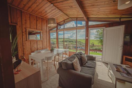 ein Wohnzimmer mit einem Sofa und einem Tisch in der Unterkunft Timber Hill Self Catering Cedar Lodges in Broad Haven