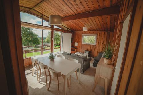 een woonkamer met een tafel en een bank bij Timber Hill Self Catering Cedar Lodges in Broad Haven