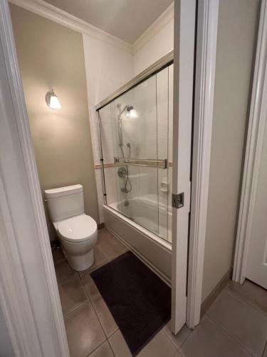 a bathroom with a toilet and a glass shower at A cozy bedroom with a private washroom close to YVR Richmond in Richmond