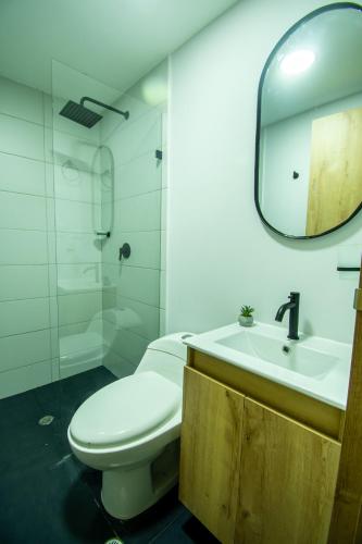 a bathroom with a toilet and a sink and a mirror at Barcelo Coliving in Medellín