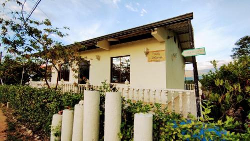a white fence in front of a small house at FINCA VILLA MAGALY en medio de la Naturaleza in Melgar