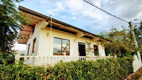 a white house with a fence in front of it at FINCA VILLA MAGALY en medio de la Naturaleza in Melgar