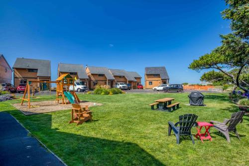 a park with chairs and a playground with houses at Breakers Beach House 9 - Meredith Lodging in Neskowin