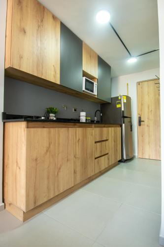 a kitchen with wooden cabinets and a refrigerator at Barcelo Coliving in Medellín