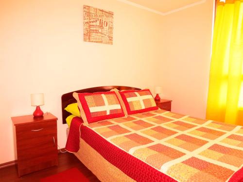 a bedroom with a bed with red and yellow pillows at Metroapart 1 in Santiago