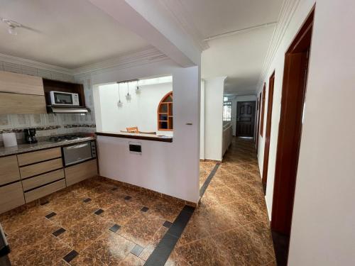 a kitchen with white cabinets and a tile floor at Best Location near Mayorca Mall Up to 10 guest in Sabaneta