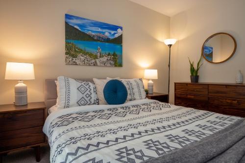 a bedroom with a bed and two lamps and a mirror at Great Location with Pool and Hot Tub by Harmony Whistler in Whistler