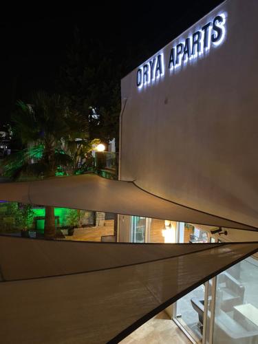 a sign on the side of a building at night at Orya Aparts in Gümbet