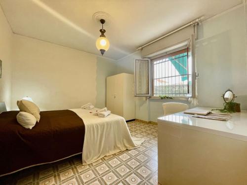 1 dormitorio con cama, escritorio y ventana en Quadrilocale Free Parking, en Loano