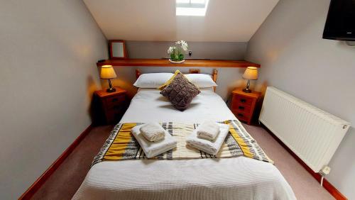 um quarto com uma cama com toalhas em Cader Mountain View Cottage with Hot Tub in Snowdonia em Dolgellau