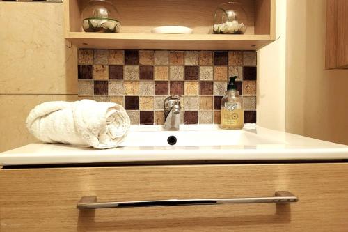 un lavabo con una toalla en la encimera en L'Essentiel - Appartement lumineux proche de tout, en Arcueil