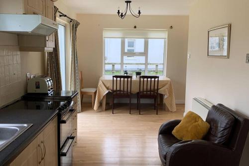 a kitchen and dining room with a table and chairs at Elegant Lahinch/ Liscannor Cottage 3B 3BR in Liscannor