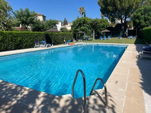 ein großer Pool mit blauem Wasser in der Unterkunft Atuaire Home Sevilla in Mairena del Aljarafe