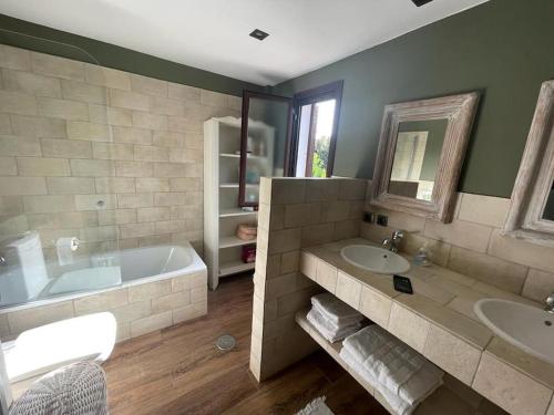 a bathroom with a tub and two sinks and a bath tub at Atuaire Home Sevilla in Mairena del Aljarafe