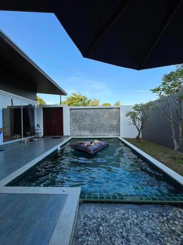 a woman laying in a pool in a house at Sand House in Chaweng