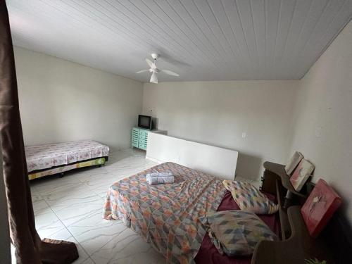 イグアバ・グランデにあるCasa iguaba com área de lazerのベッドルーム1室(ベッド1台、シーリングファン付)