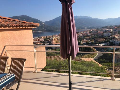 an umbrella on a balcony with a view at punta di prunetu in Propriano